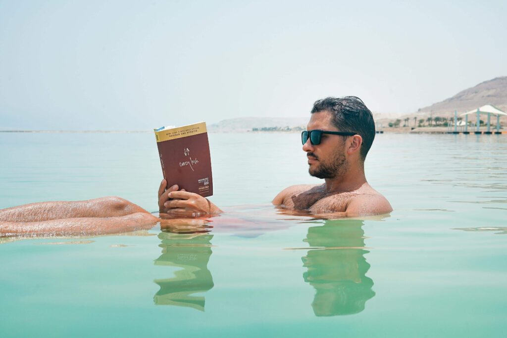 Person reading a book in a cozy setting.