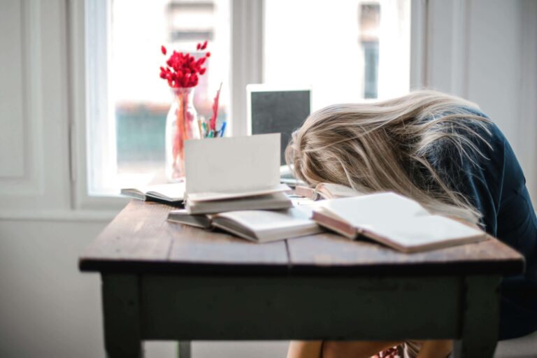 A person taking a break and stretching at their desk, symbolizing the importance of regular breaks in combating mental fatigue.